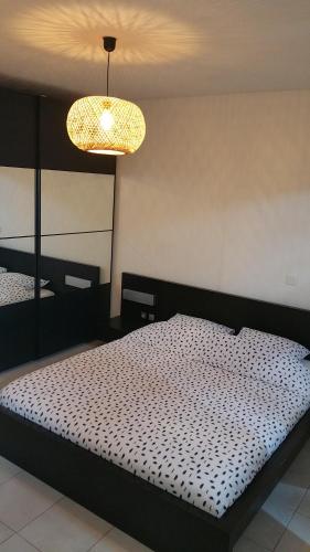 une chambre avec un lit et un lustre dans l'établissement Apt 50m2 avec Balcon tout équipé proche d'Avignon, à Pernes-les-Fontaines