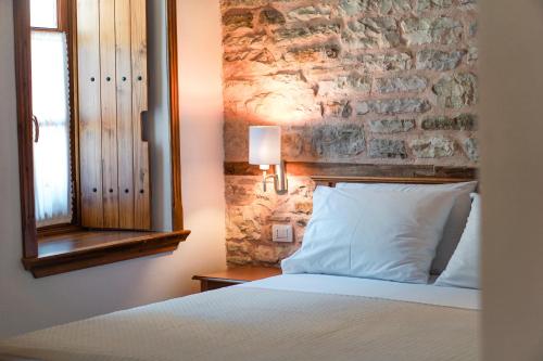 a bedroom with a bed and a stone wall at Argjiro Traditional in Gjirokastër