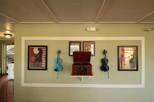 a room with a wall with acoustic guitars on it at Fiddlers Inn Opryland in Nashville
