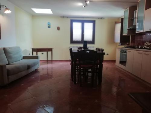 a kitchen and living room with a table and a couch at La casa delle fate in Giave