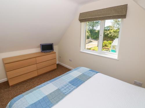 Schlafzimmer mit einem Bett und einem Fenster in der Unterkunft Mill View in Milford Haven