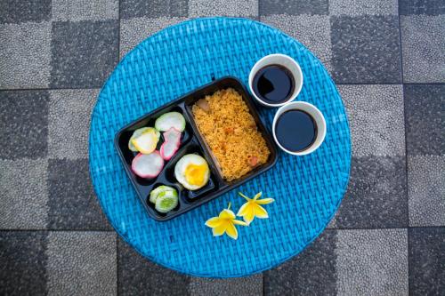 a blue plate with a tray of food on a table at Titanium Express HomTel in Jakarta