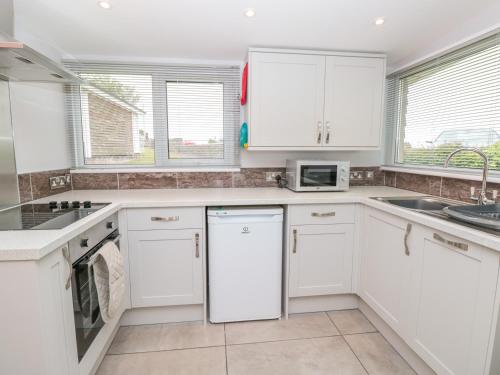 a white kitchen with white cabinets and appliances at 201 Norton Park in Dartmouth
