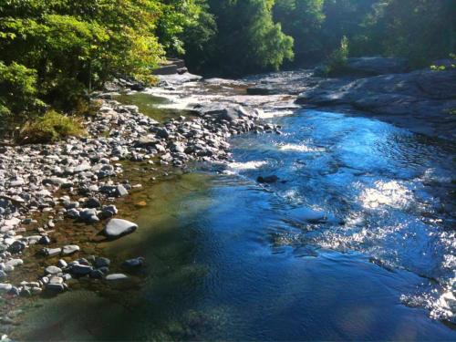 a river with rocks and blue water and trees at Play All Day - Sleep By The Stream at Night - Swimming Hole in Palenville