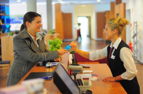 two women shaking hands at a counter in a store at Hotel Franz in Essen