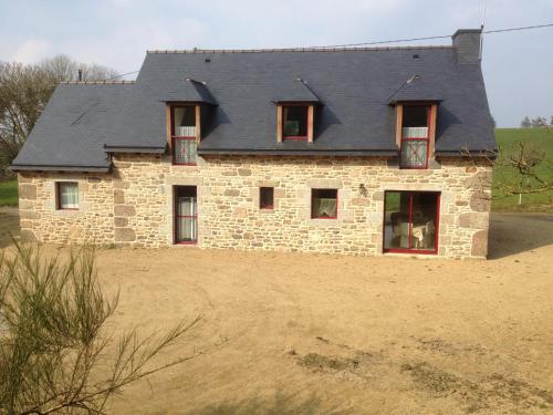 a stone house with a gray roof on a field at Kerkleir in Saint-Gilles-Pligeaux