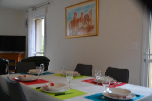 a table with plates and wine glasses on it at Kerkleir in Saint-Gilles-Pligeaux