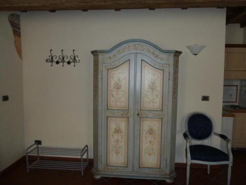 a room with a large wooden cabinet and a chair at Il Giardino Fiorito in Ferrara