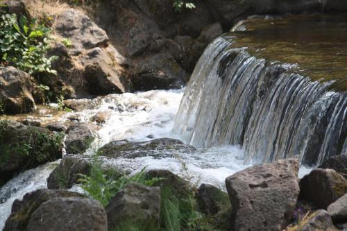 a stream of water flowing over rocks in a waterfall at Bungalow; Haus 111 Ferienpark Twistesee, Bad Arolsen in Bad Arolsen