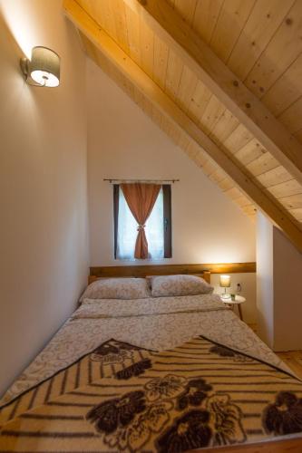 a large bed in a room with a window at Brvnare Krstigora in Zaovine