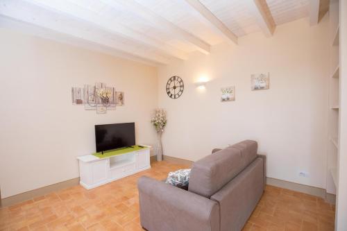 a living room with a couch and a tv at Agriturismo Colle Oliveto in Orbetello