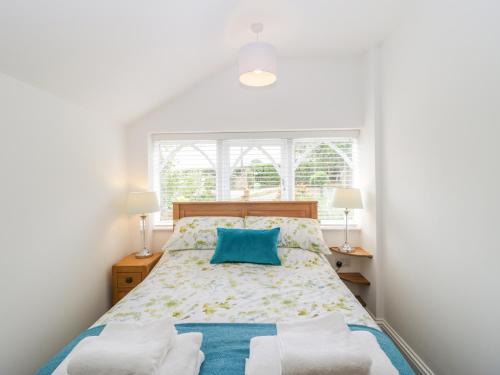 a bedroom with a bed with a blue pillow and two lamps at Boundary Barn in Bristol