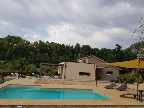 a swimming pool in front of a house at Folco Studio Apartment in Piazza Armerina