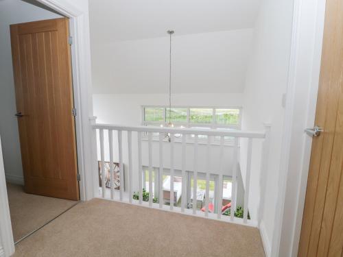 a white staircase with a window in a room at Waterside in Chathill
