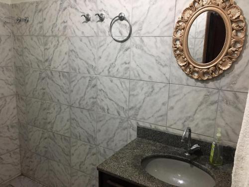 a bathroom with a sink and a mirror on the wall at Casa para temporada - Chapada das Mesas in Carolina