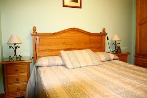 sypialnia z drewnianym łóżkiem i 2 szafkami nocnymi w obiekcie Los Olivos w mieście Arroyo Frio