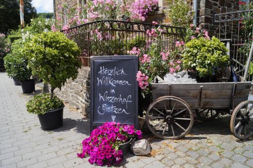 a sign next to a cart full of flowers at Winzerhof Gietzen in Hatzenport