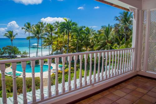 a balcony with a view of the beach and palm trees at Hotel Villa Serena in Las Galeras