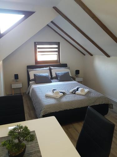 a bedroom with a bed with two towels on it at Studio Apartmani Patricia in Smoljanac