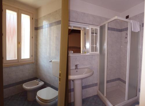 a bathroom with a toilet a sink and a shower at Il Giardino Fiorito in Ferrara