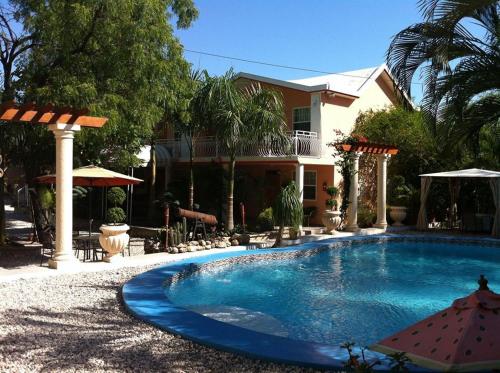 une grande piscine devant une maison dans l'établissement Palm Inn Hotel, à Port-au-Prince