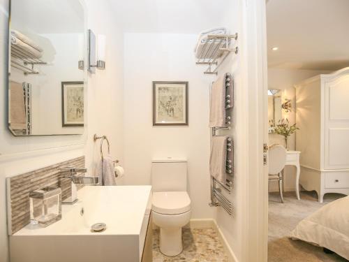 a white bathroom with a toilet and a sink at Shutts House Garden Apartment in Salisbury