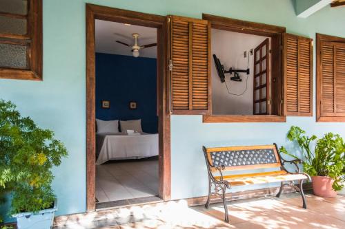 a door to a patio with a bench and a bed at Pousada Recanto da Serra in Serra do Cipo