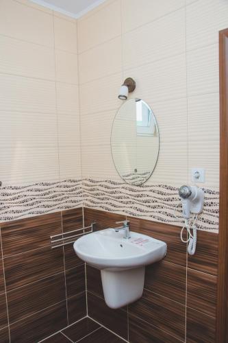 a bathroom with a sink and a mirror at Pensiunea Iliada in Sibiu
