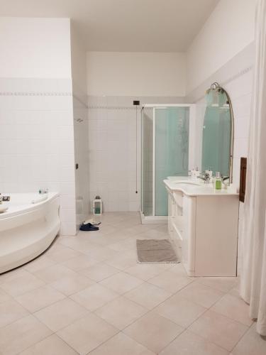 a white bathroom with a tub and a sink and a bath tub at B&B Tenuta Madiba in Ravenna