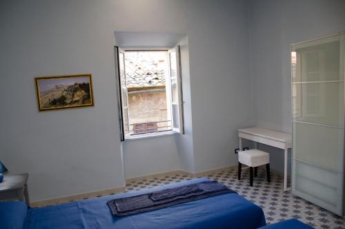 a bedroom with a blue bed and a window at volterracentro in Volterra