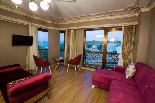 a living room with a red couch and a large window at Empire Suite Hotel in Istanbul