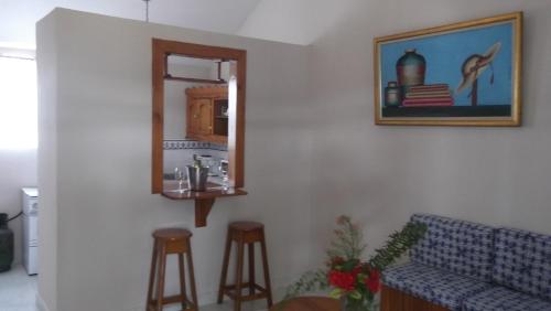 un salon avec un canapé, un miroir et des tabourets dans l'établissement Palm Inn Hotel, à Port-au-Prince
