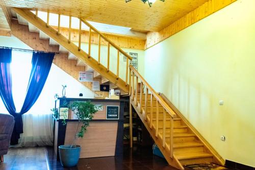 a staircase in a living room with a stair case at Pensiunea Marmis in Rîu Bărbat