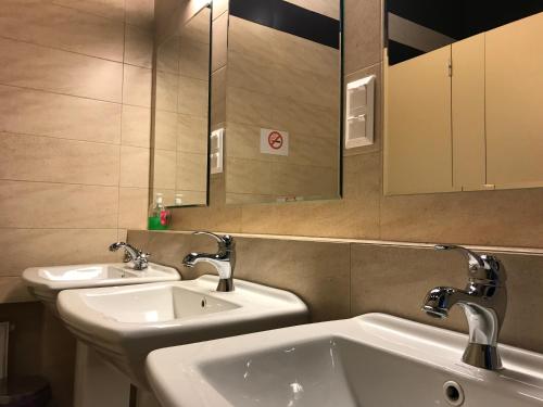 Baño con 2 lavabos y espejo en Loft Car Factory, en Varsovia
