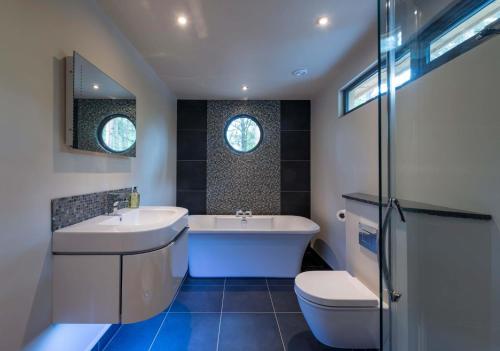 Un baño con bañera, lavabo e inodoro. en Bracken Howe Lodge, en Whitby