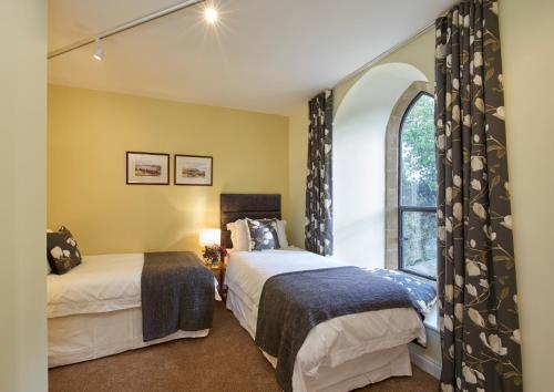 Un dormitorio con dos camas y una ventana. en Chapel-on-the-Hill, en Grosmont