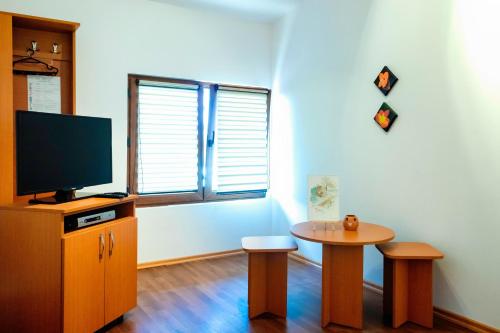 a living room with a tv and a table and a tvictericter at Pensiunea Marmis in Rîu Bărbat