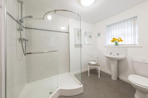 a bathroom with a shower and a toilet and a sink at Church View in Whitby