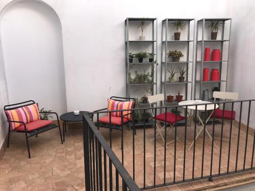 a room with chairs and a table and shelves with plants at Palacio Torneria in Jerez de la Frontera