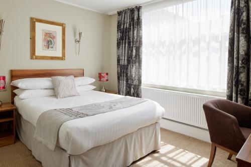 a bedroom with a large bed and a window at Alma Lodge Hotel in Stockport