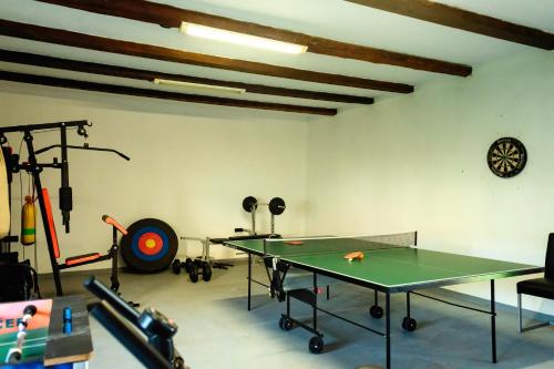 a room with a ping pong table and gym equipment at Pensiunea Marmis in Rîu Bărbat