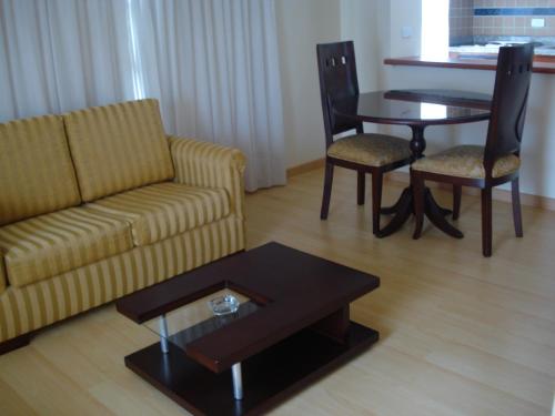 sala de estar con sofá, mesa y sillas en Apartamentos Santa Maria en Bogotá