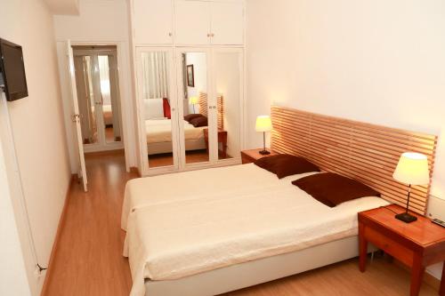 a bedroom with a large white bed and a mirror at Casa Encantada - Poeta in Lisbon