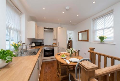 a kitchen with a wooden table and a counter top at Gavel Cottage in Whitby