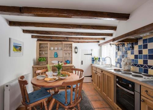 a kitchen with a wooden table and chairs at Fossil Cottage in Whitby
