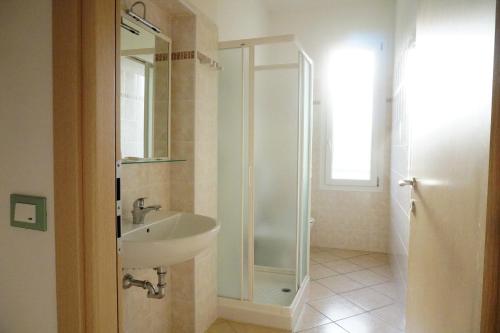 a bathroom with a sink and a glass shower at Villa Serena in Rosolina Mare