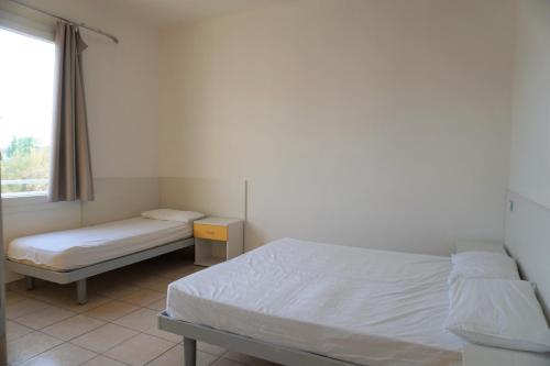 a bedroom with two beds and a window at Villa Serena in Rosolina Mare
