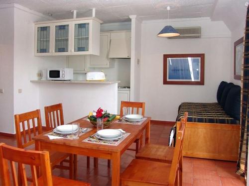 uma cozinha e sala de jantar com mesa e cadeiras em Apartamentos Turisticos Regina em Albufeira