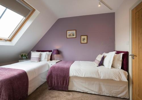 2 camas en un dormitorio en el ático con paredes moradas en Limber View, en Grosmont