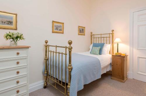 a bedroom with a bed and a dresser at Manor Cottage in Whitby